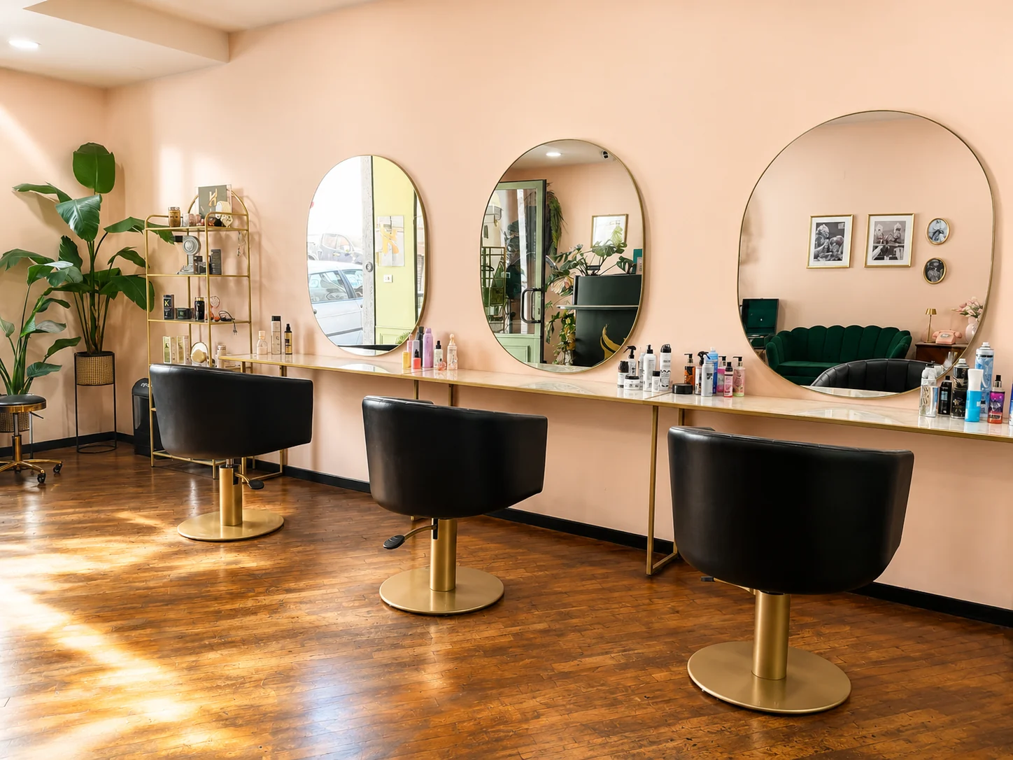 Interno di Haniel Hair Atelier: postazioni con specchi tondi oro e poltrone